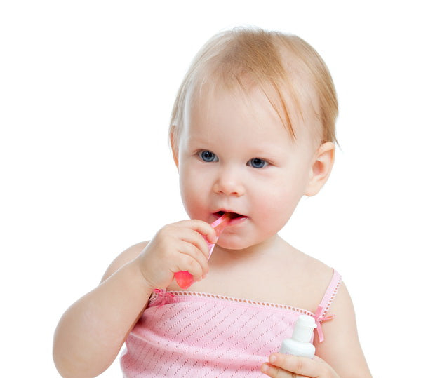 Toddler Brushing Teeth with Pink Toothbrush and Holding Toothpaste