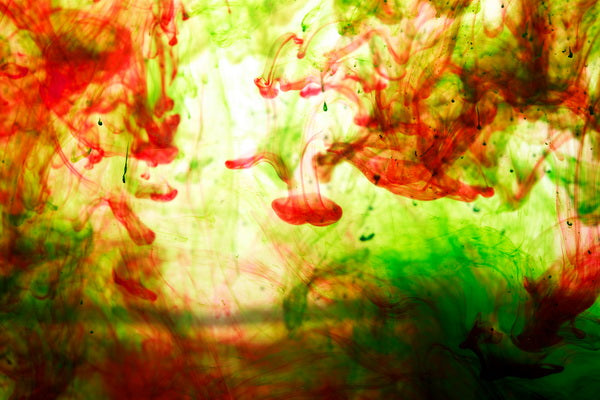 Vibrant Red and Green Ink Swirling in Water