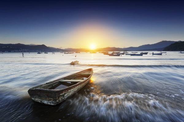 Sunrise by the Shore: A Forgotten Boat at Dawn